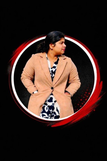 Freelance digital marketing expert in Kochi, Amala Limson, standing confidently in a professional portrait with a modern black and red background.